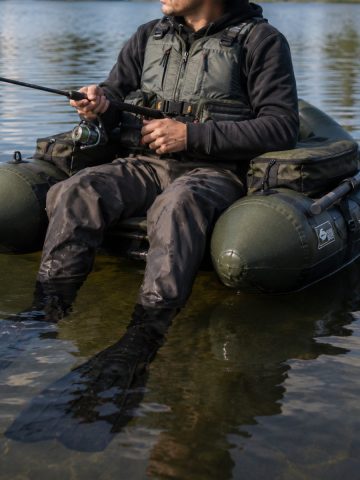 Pêcheur en float tube équipé d'un gilet de sauvetage sur eau calme